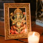 Elegant Ganesha picture with candle signifies spiritual ambiance in a cozy setting.